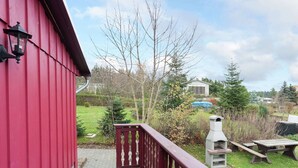 A red building with a wooden deck and a barbecue grill in the yard. - Quaint Holiday Home in Güntersberge near Lake (Harzgerode)