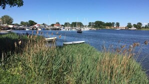 A marina with boats docked, surrounded by greenery and buildings in the background. - Insel- Bungalow auf Poel (Insel Poel)