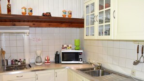 A kitchen with white cabinets, a microwave, a coffee maker, and a sink. - Cottage in the Heart of the Ardennes Woods (Manhay)