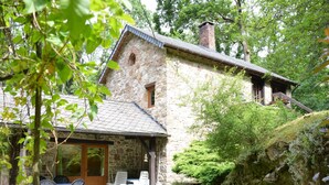 A stone house with a patio and outdoor seating area. - Cottage in the Heart of the Ardennes Woods (Manhay)