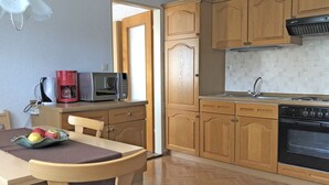 A kitchen with wooden cabinets, a microwave, a coffee maker, and a sink. - Garden Apartment, Gobweinstein (Goessweinstein)