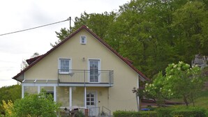 A two-story building with a balcony, a small porch, and a front door. - Garden Apartment, Gobweinstein (Goessweinstein)