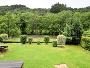 A lush garden with neatly trimmed hedges and a river in the background. - Peaceful Stay in Remouchamps (Aywaille)