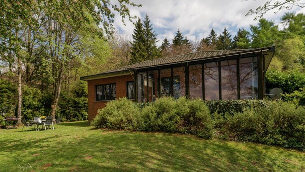 A modern house with a glass conservatory, surrounded by lush greenery and trees. - Holiday Home in Waimes With Private Garden (Waimes)