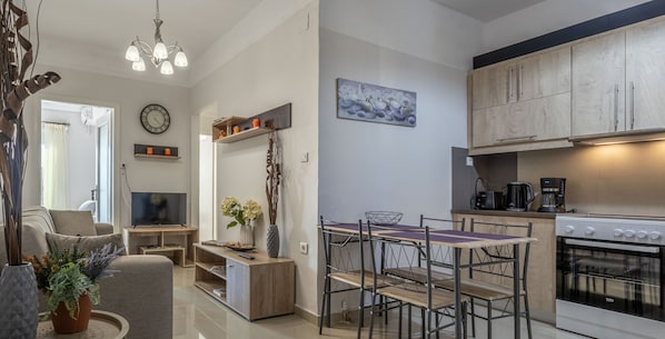 A modern kitchen with a dining area, wooden cabinets, and a built-in oven.