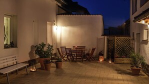 A patio area with a table and chairs, potted plants, and a bench. - Holiday Home Near the Forest in Thale (Thale)