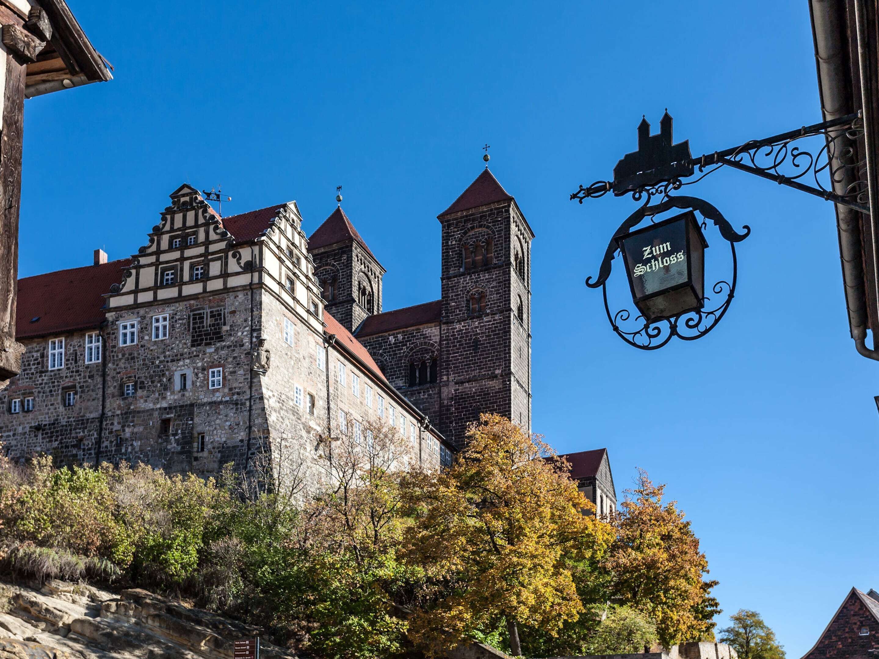 A historic stone building with a prominent tower and a traditional half-timbered facade.