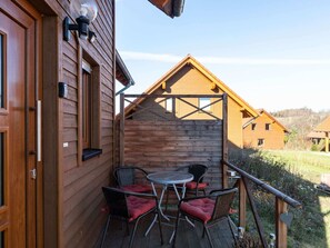 A wooden building with a balcony featuring a table and chairs. - Ferienhaus in Hasselfelde (Oberharz am Brocken)