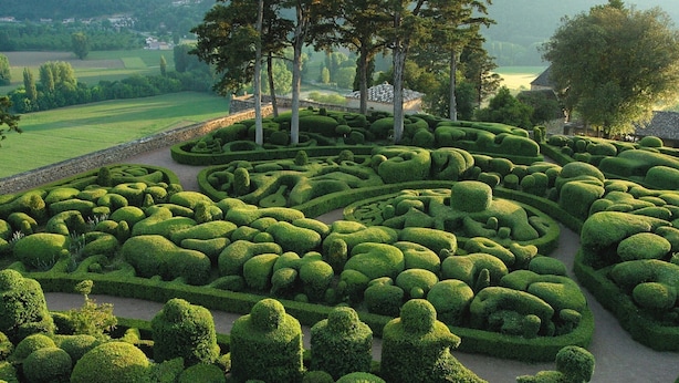 A meticulously landscaped garden with geometric topiary designs and a stone pathway. - Cozy Cottage Retreat in Vezac (Vezac)