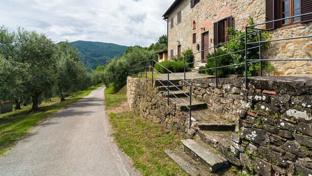 A stone building with a paved road leading through a rural landscape. - Belvilla by OYO Casa Luna (Pescia)