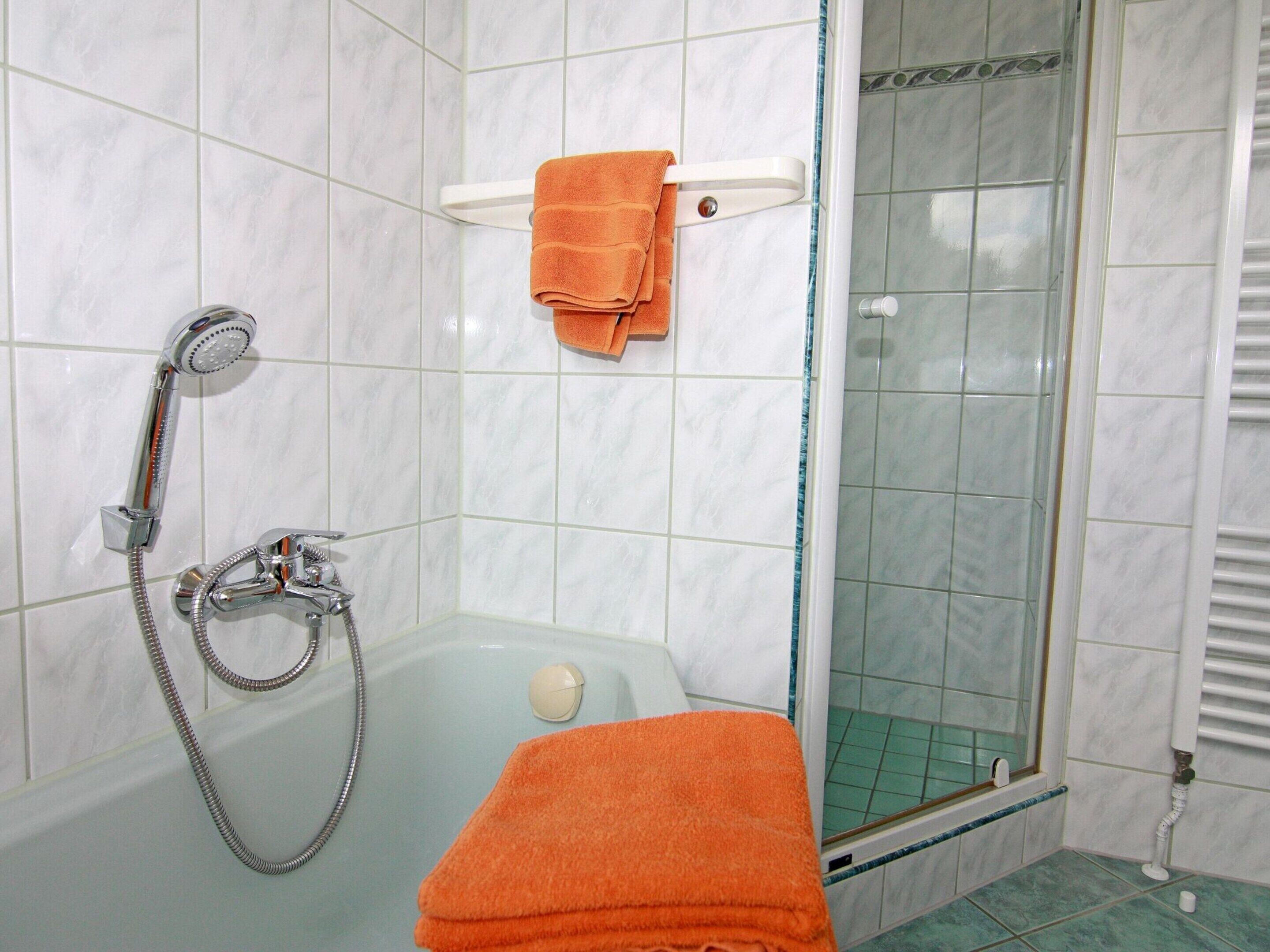 Ein Badezimmer mit Dusche, Badewanne und einer Duschkabine.