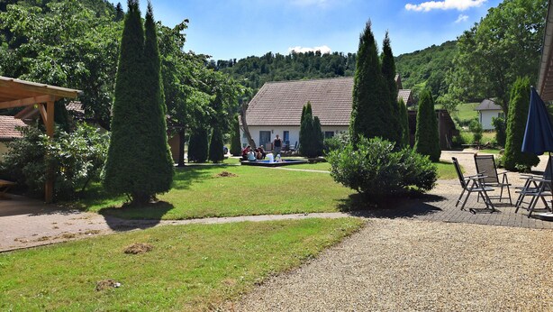 A courtyard with a gazebo, neatly trimmed hedges, and a gravel path leading to outdoor seating. - Charmante Wohnung mit Eigener Terrasse (Bad Wildungen)