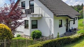 A two-story house with a balcony, a fenced yard, and a well-maintained garden. - Attic Apartment, Herrischried (Herrischried)