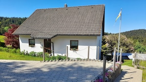 A white building with a tiled roof, a paved entrance, and a flagpole. - Attic Apartment, Herrischried (Herrischried)
