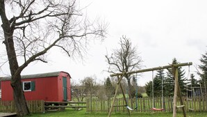 Ein Spielplatz mit Schaukeln und einem roten Gebäude im Hintergrund.