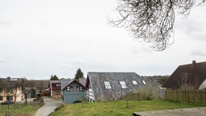 Ein Wohngebiet mit Häusern, einem Rasen und einer Holzterrasse.