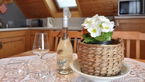 A table with a bottle of Hugo wine, a glass, and a woven basket with flowers. - Holiday Home Beerheide Near Ski Slopes (Auerbach)