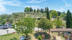 A hillside garden with a pergola, potted plants, and a table. - Villa in Monterotondo With Pool & Tiber Views (Monterotondo)