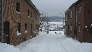A snow-covered street with brick buildings on either side. - Holiday Home in Epen With Garden & BBQ (Epen)