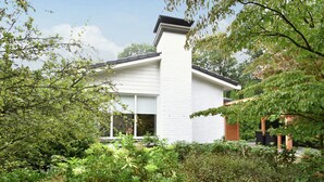 A modern house with a white exterior, surrounded by lush greenery and trees. - Holiday Home in Holten Near Holterberg (Holten)