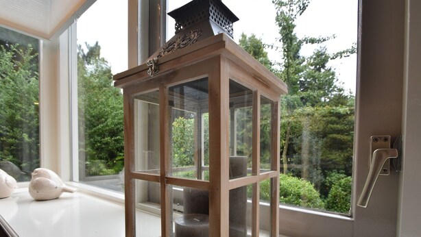A wooden lantern with a glass enclosure on a windowsill. - Holiday Home in Holten Near Holterberg (Holten)