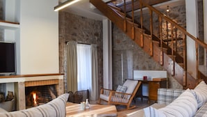 A cozy living room with a fireplace, a wooden staircase, and a comfortable seating area. - Secluded Mountain Refuge - Theonimfi Paradise Gem (Gortynia)