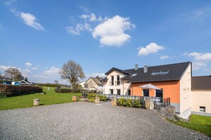 Un quartier résidentiel avec des maisons, une allée gravillonnée et un ciel dégagé.