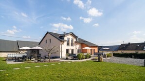 A residential area with houses, a grassy lawn, and outdoor furniture. - Eifel Lakeside Family Escape (Ellscheid)
