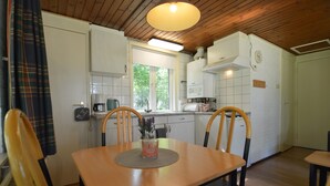 A compact kitchen with white cabinets, a coffee maker, and a window. - Detached Bungalow With Lovely Covered Terrace (Stramproy)