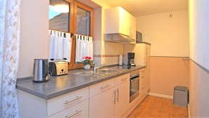 A compact kitchen with a toaster, sink, stove, and a small trash bin. - Forest Hideaway for 2 Guesst (Kirchhundem)