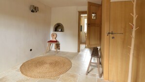 A room with a large woven rug, a wooden chair, a small table, and a wardrobe with a mirror. - Holiday Home in Bullange With Sauna (Buellingen)
