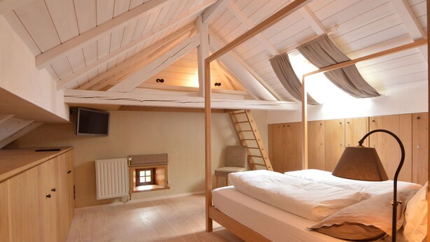 A compact, wooden-furnished room with a bunk bed, a desk, a chair, a ladder, and a small window. - Holiday Home in Bullange With Sauna (Buellingen)