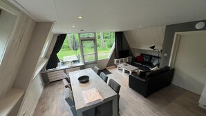 A modern loft-style living space with a dining area, kitchen, and seating area. - Bungalow in Limburg Near Nature Reserves (Stramproy)