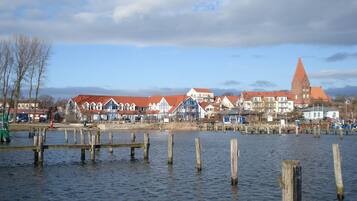 Eine Stadt am Wasser mit traditioneller Bebauung und einem markanten Kirchturm.