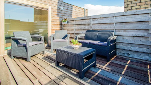 An outdoor patio with wicker furniture, a small table, and a potted plant. - Apartment in Watou Near French Border (Poperinge)