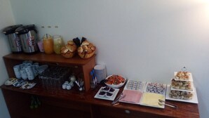 A buffet setup with various food items and beverages. - Munayki Hotel (Tacna)