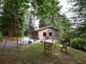 A rustic cabin with a swing set, outdoor seating, and a garden area. - Chalet in a Green and Peaceful Environment (Houffalize)