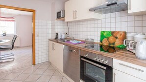 A modern kitchen with white cabinets, a microwave, a coffee maker, and a toaster. - Wohnung in der Nahe des Skigebietes Battenberg (Battenberg)
