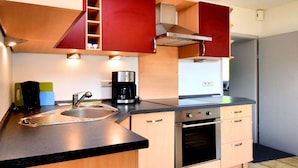 Una cucina moderna con forno integrato, macchina del caffè e mobili in legno.