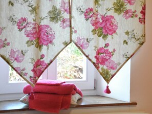 A room with a window, a pink towel on the sill, and floral-patterned curtains. - Charming Holiday Home in the Ardennes in Laneuville-au-bois (Tenneville)