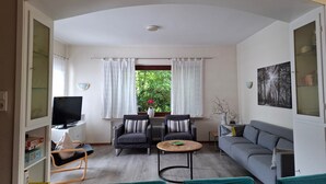 A living room with a sofa, two armchairs, a coffee table, a TV, and a bookshelf. - Apartment in Willingen Near Ski Lift (Willingen)