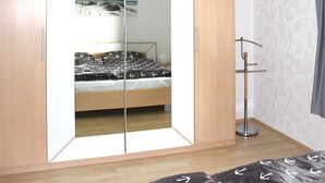 A bedroom with a bed, a wardrobe, and a floor lamp. - Apartment in Bodenwerder mit Balkon (Bodenwerder)