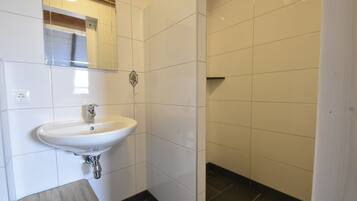 A bathroom with a white sink, a mirror, and a towel rack.