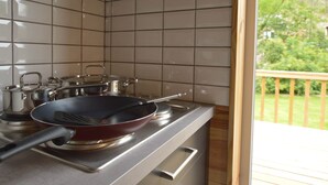 A kitchen with a gas stove, pots, and a frying pan. - Chalet Near Durbuy With Private Garden (Ferrieres)