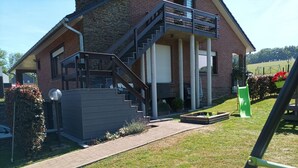A two-story house with a brick exterior, a covered porch, and a staircase leading to the upper floor. - Peaceful Escape, Malmedy (Malmedy)