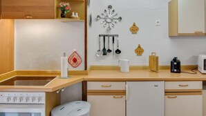 A modern kitchen with wooden cabinets, a built-in oven, a sink, and a coffee maker. - Holiday Home in the Forest (Schmogrow)
