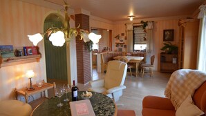 Una sala de estar acogedora con una mesa redonda, un sofá y una zona de comedor con un banco.