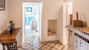 A narrow hallway with a sewing machine, a large vase, and a wicker basket. - Quaint Holiday Home in Lecce Apulia near Town Center (Casarano)