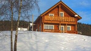 A wooden cabin with a balcony, surrounded by snow and trees. - Ferienhaus, Wissinghausen (Medebach)