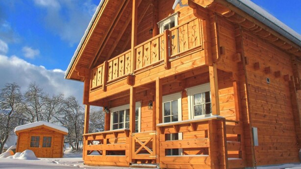 A wooden cabin with a balcony, a small attached shed, and a snow-covered landscape. - Ferienhaus, Wissinghausen (Medebach)